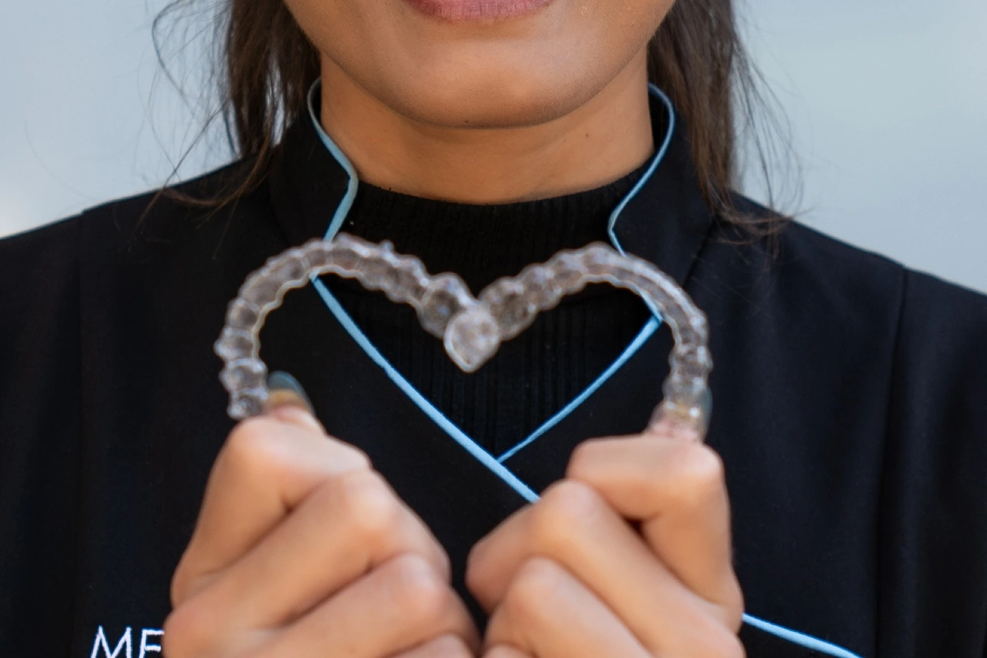 Adult holding an Invisalign clear aligner Adult holding an Invisalign clear aligner